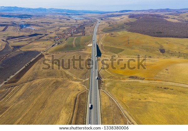 Aerial top view of cars and trucks passing on a\
highway, drone shot