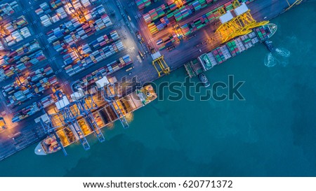 Aerial top view container cargo ship waiting for loading at night, import export business logistic and transportation by ship in open sea.