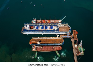 Aerial Top View Container Oil Ship In Shipyard For Repair And Maintenance In Green Sea 