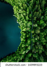 Aerial Top View Of Country Road In Green Summer Forest And Blue Lake. Rural Landscape In Finland. Drone Photography From Above.