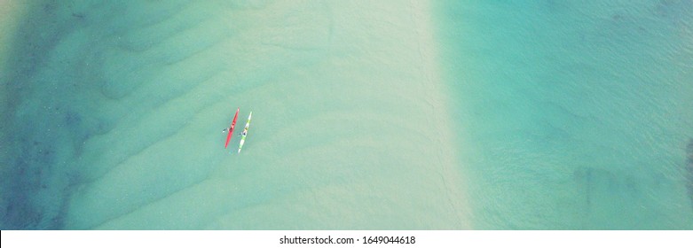 Aerial Top View Of Couple People Kayaking Over Blue Creek Ocean, Drone Shot For Reopen Tourism Tour  Holidays Destination, Retreat Peaceful Relaxation, Well Being And Wellness Concept