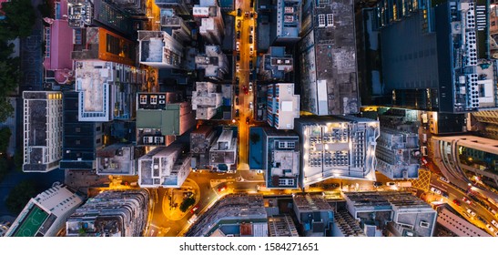 Aerial top view of downtown district  buildings in night city light. Bird's eye view from drone of cityscape metropolis infrastructure, crossing streets with parked cars. Development infrastructure