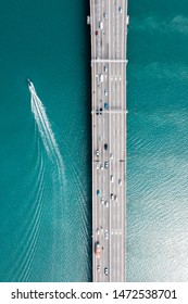 Aerial Top View. Drone Photo Of Penang Water Bridge With Moving Traffic Of Yachts And Cars.