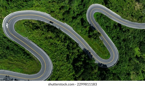 aerial top view drone shot ROAD No.1081 or shape number three of winding mountain road between Pua District, Nan Province, Thailand is highlight point and landmark that tourist like to take pictures 