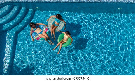 Aerial Top View Of Family In Swimming Pool From Above, Mother And Kids Swim And Have Fun In Water On Family Vacation In Hotel Resort
