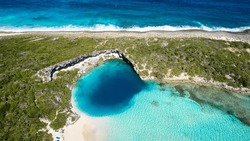 Aerial Top View Of The Famous Dean's Blue Hole With The Connecting Turquoise Lagoon Next To The Blue Ocean, Long Island, Bahamas