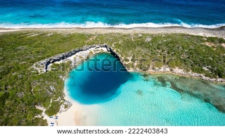 Aerial top view of the famous Dean's blue hole with the connecting turquoise lagoon next to the blue ocean, Long Island, Bahamas