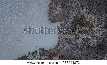 Aerial top view of first snow trees and lake