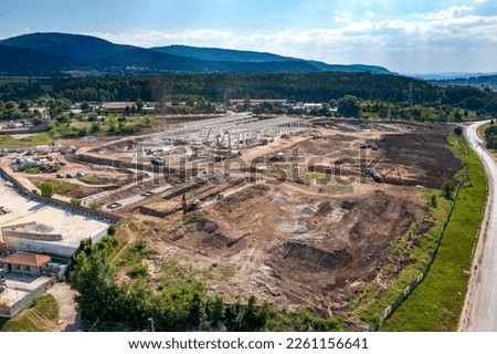 Aerial top view of huge construction site with many working heavy machines