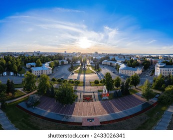 Aerial top view to Lenin square at sunset. Memorial Eternal Flame in center of city near Park Onezhskogo Traktornogo Zavoda in sunny evening. Petrozavodsk city is capital of Karelia. Russia