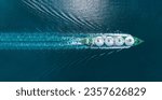 Aerial top view LNG Tanker ship (Liquefied Natural Gas) with contrail in the ocean sea ship carrying container and running for export from container international port to custom ocean concept 