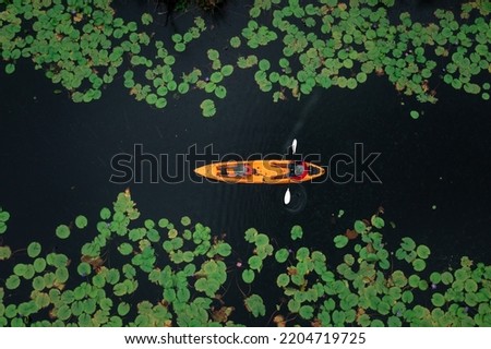 aerial top view of man paddling kayaking in the green leave lotus lake at rayong botanical garden in thailand For tourist services.