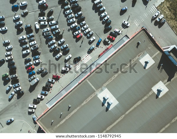aerial top view of many cars on the messy parking near\
the shopping center 