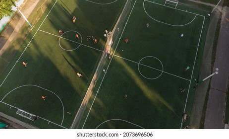 Aerial Top View Of Mini Football Green Field With Artificial Grass Made During The Soccer Match Of Amateur Teams At Summer Day