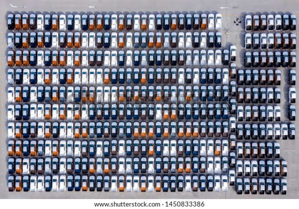 Aerial top view new\
cars lined up in the port for import export business logistic and\
transportation by ship in the open sea. New cars from the car\
factory parked at the port\
