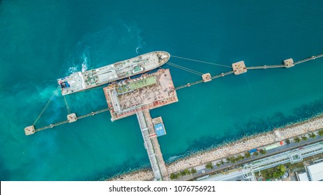 Aerial top view of oil tanker ship at the port, Oil terminal is industrial facility for storage of oil and petrochemical products ready for import export business logistic and transportation