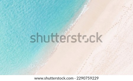 Aerial top view on nature landscape view of beautiful tropical clean sandy beach and soft blue ocean. Aerial top-down drone view.