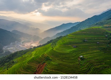 Aerial Top View Of Paddy Rice Terraces, Green Agricultural Fields In Countryside Or Rural Area Of Mu Cang Chai, Yen Bai, Mountain Hills Valley At Sunset In Asia, Vietnam. Nature Landscape Background.