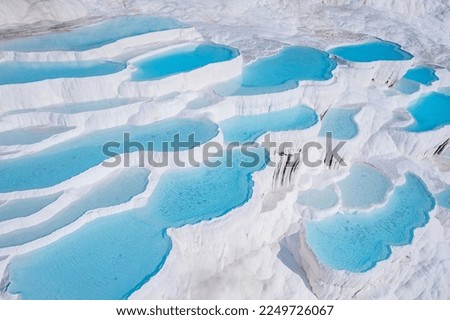 Aerial top view Pamukkale Turkey travertine pools, nature terraces with blue water.