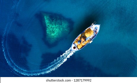 Aerial top view photo of beautiful traditional fishing boat from famous small picturesque village of Parga with turquoise crystal clear sea, Ionian, Greece