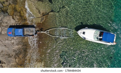 Aerial top view photo of speed boat on trailer being towed by truck from emerald exotic sea to land - Powered by Shutterstock