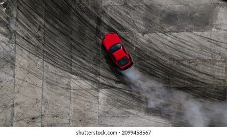 Aerial top view professional driver drifting car on asphalt road track with white smoke, Automobile race car drift on abstract asphalt road with black tire skid mark, View from above. - Shutterstock ID 2099458567