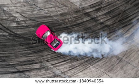 Aerial top view car drifting on asphalt race track with start and finish  line and lots of smoke from burning tires, Auto or automobile background  concept. Stock Photo