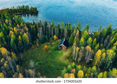 Aerial Top View Of Red Log Cabin Or Cottage With Sauna In Spring Forest By The Lake In Rural Finland