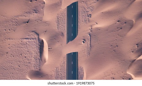 An aerial top view of roads through sand dunes in Dubai, UAE