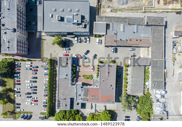 aerial top view of roofs of\
industrial warehouses and parked cars at city industrial\
district