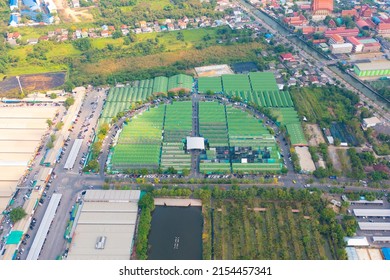 Aerial Top View Of Sanam Luang Street Market , Green Roof Tops, Horse Shoe Shape Drive Thru And Parking Area. Tents With Retail Shops.