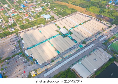 Aerial Top View Of Sanam Luang Street Market , Green Roof Tops, Horse Shoe Shape Drive Thru And Parking Area. Tents With Retail Shops.