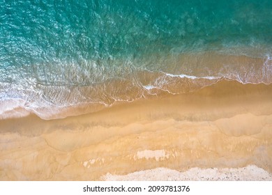aerial top view sea waves seamless loop on the white sand beach. Wave after wave swept towards the shore. green sea, white bubble waves,and clear sand landscape. Paradise beach.