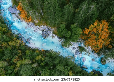 An aerial top view of the Soca river flowing through a forest in Slovenia in autumn - Powered by Shutterstock