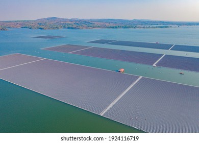 Aerial top view of solar panels or solar cells on buoy floating in lake sea or ocean. Power plant with water, renewable energy source. Eco technology for electric power in industry.