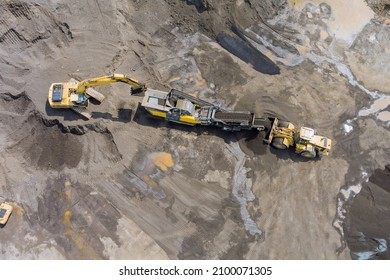 Aerial top view of the stone crusher conveyor belt heavy excavators loading stones into the crusher with heavy equipment machines