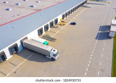 Aerial Top View Of Truck And Cargo Trailer Unloading In Logostics Center.