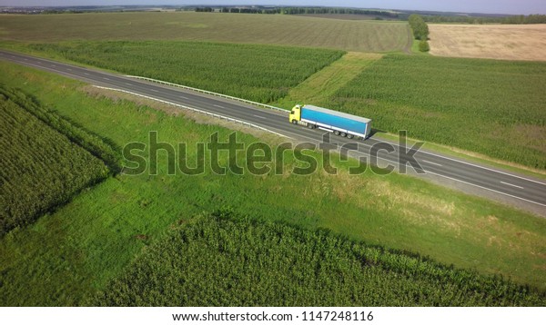 Aerial Top View of\
Truck with Cargo Semi Trailer Moving on Road in Direction f Loading\
Warehouse Area.