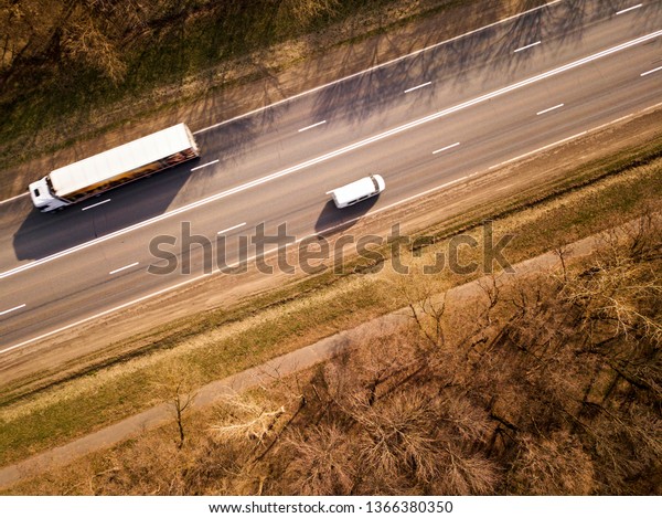 Aerial Top View of Truck with Cargo Semi\
Trailer Moving on Road in\
Direction.
