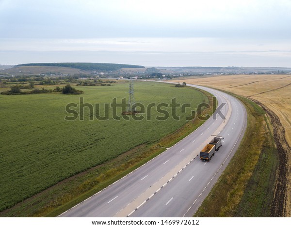 Aerial Top View of Truck with Cargo Semi\
Trailer Moving on Road in\
Direction.