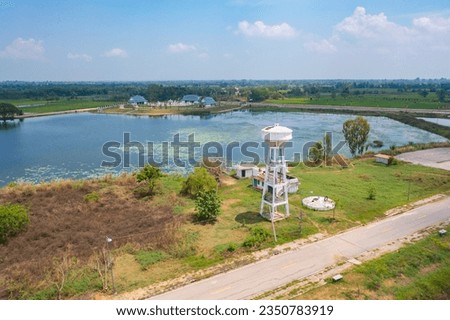 Aerial top view of village water supply with lake or river for agriculture. Nature landscape background. Plumbing tank utility.