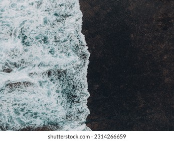 Aerial top view of waves crashing against stone rocks in the ocean wallpaper style - Powered by Shutterstock