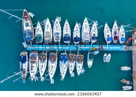 Aerial top view of a lot of white boats and yachts moored in marina. Top-down view of docked sailboats. Top down view of yachts. Luxury yacht Boat in a port. Marina lot sailboat. Harbor with boats.