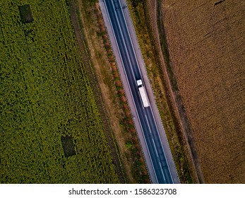 Aerial Top View Of White Truck With Cargo Semi Trailer Moving On Road In Direction.