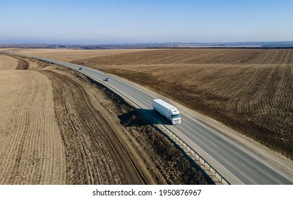 Aerial Top View Of White Truck With Cargo Semi Trailer Moving On Road In Direction.