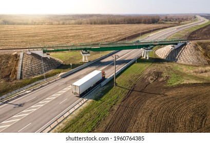 Aerial Top View Of White Truck With Cargo Semi Trailer Moving On Road In Direction. Highway Intersection Junction