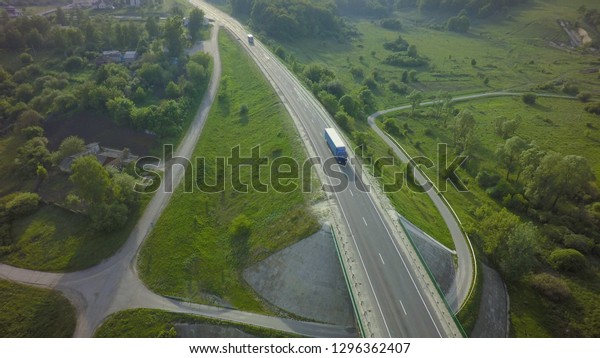 Aerial Top View of White Truck with Cargo Semi\
Trailer Moving on Road in\
Direction.