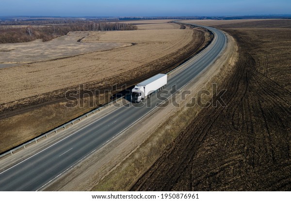 Aerial Top View of White Truck with Cargo Semi\
Trailer Moving on Road in\
Direction.