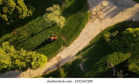 Aerial Top-down Over Red Tractor Cutting Green Grass, Uruguay