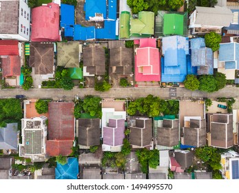 Aerial top-down view high altitude of slum a heavily populated urban informal settlement characterized by substandard housing and squalor poor living conditions streets and rusty metal home roof tops